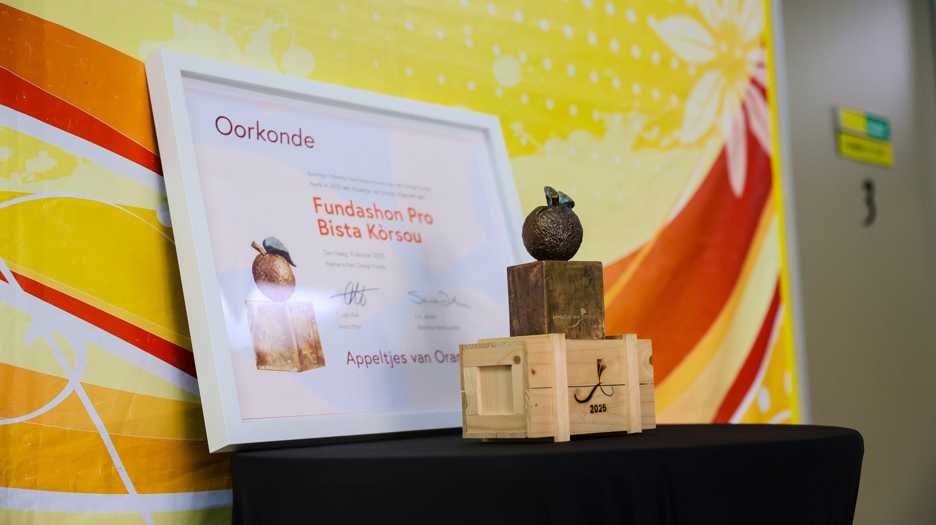 Banner of Fundashon Pro Bista Kòrsou next to the Appeltje van Oranje statuette