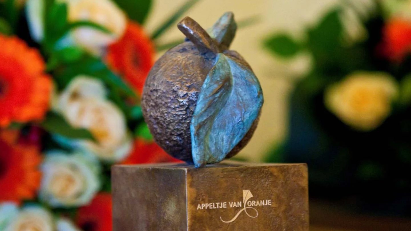 The bronze Appeltje van Oranje statuette among flowers