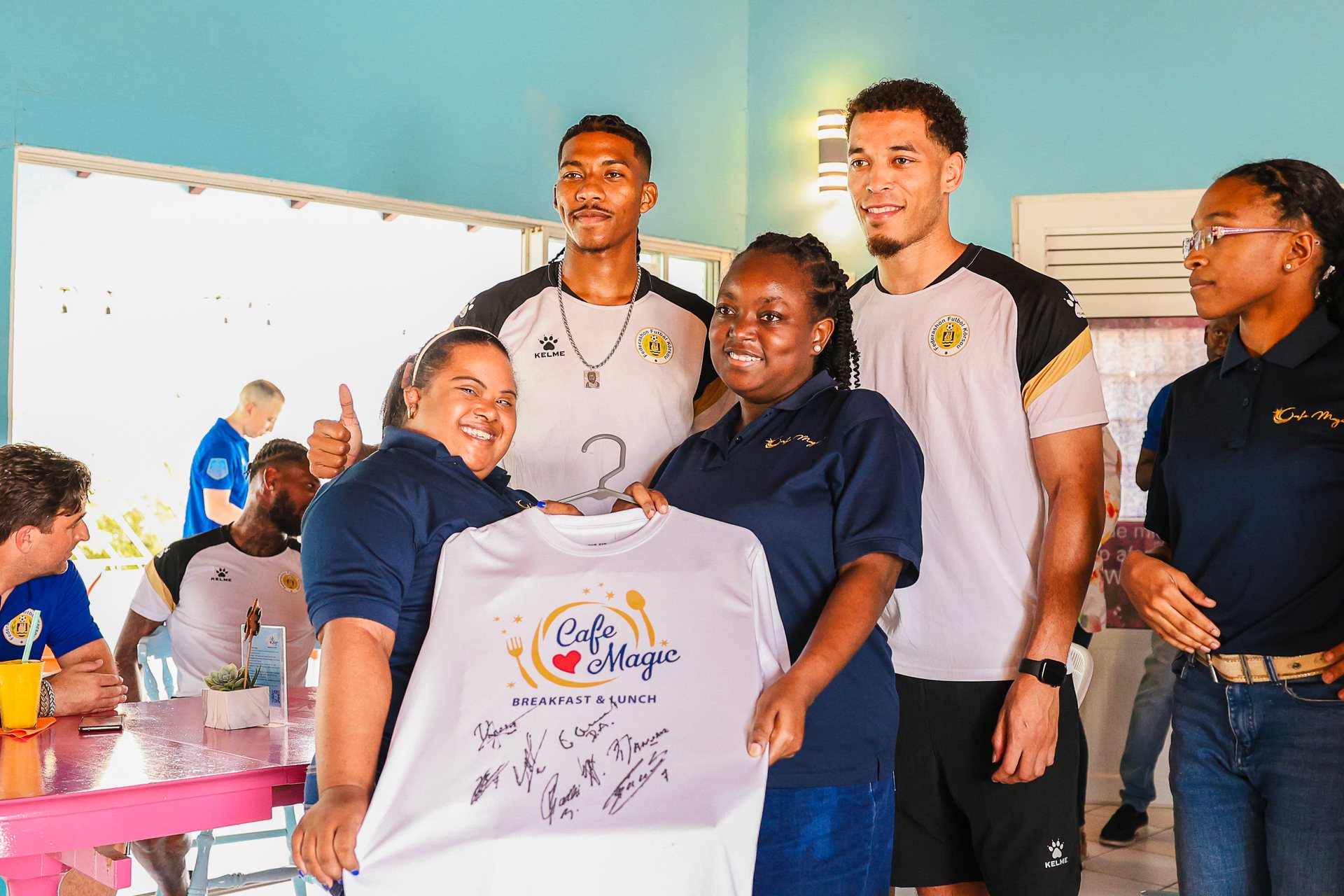 Young people and children posing with a project shirt in the classroom