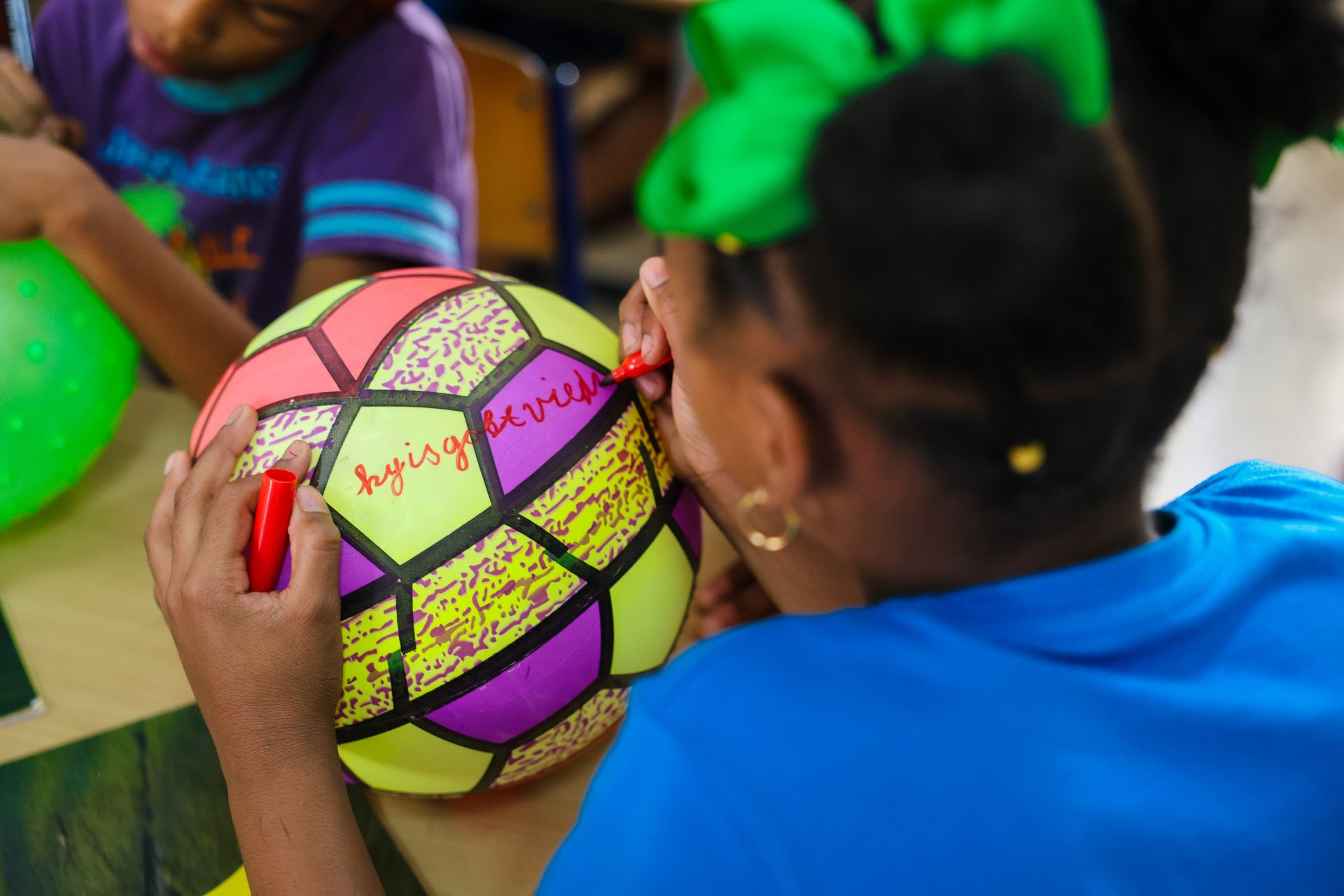 Close up of children playing with a coloured ball