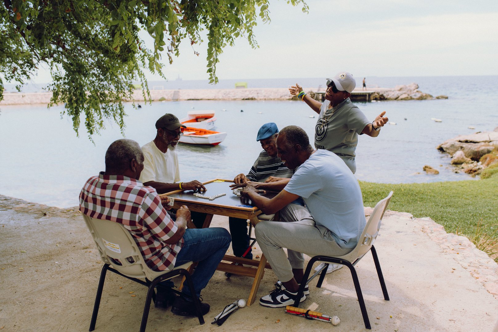 Men working at tables by the coast during an outdoor programme