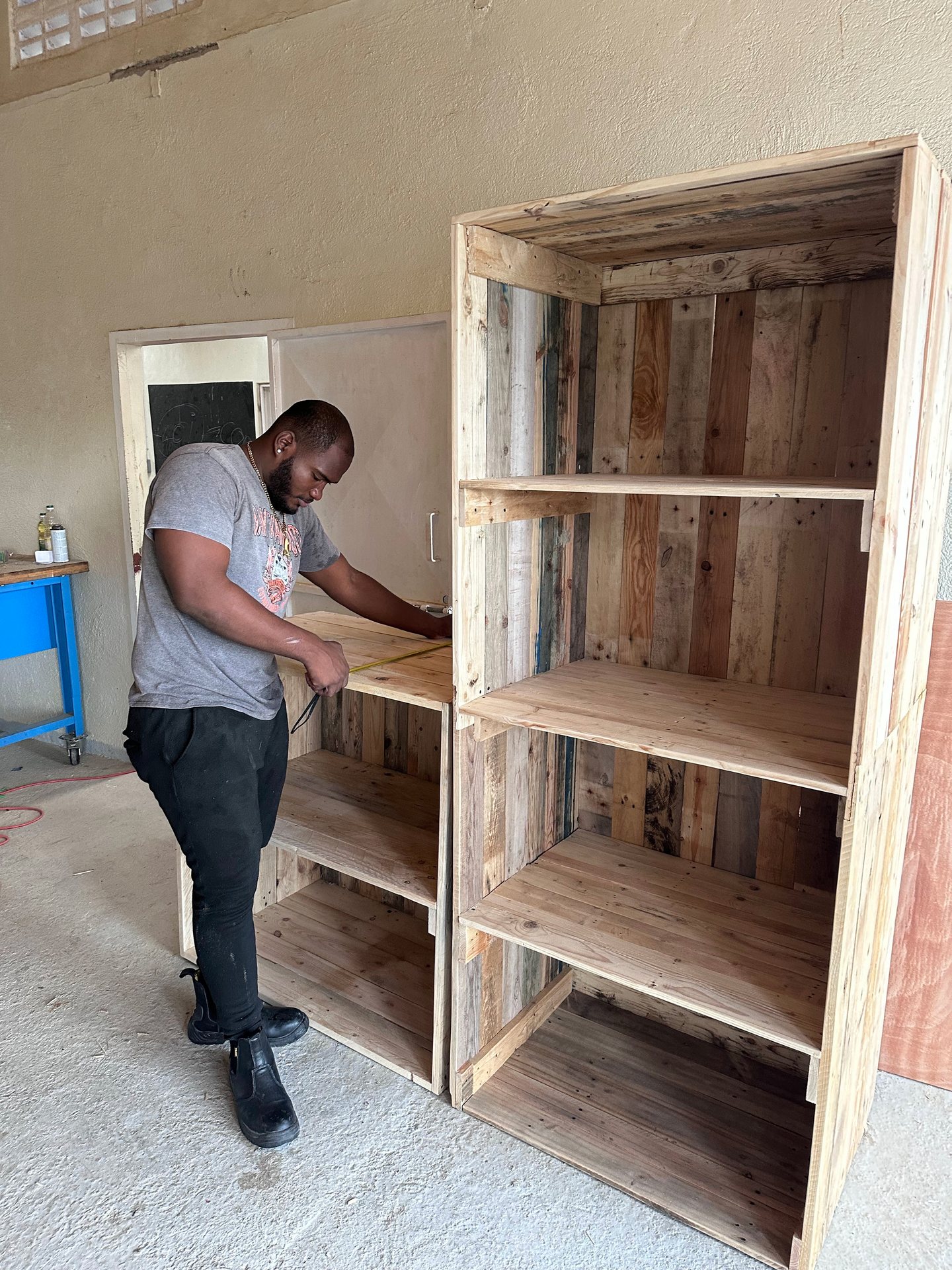 Volunteer building a wooden cupboard during a renovation